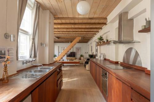 a large kitchen with wooden counters and wooden ceilings at Charming 4BR Duplex in Nørrebro in Copenhagen