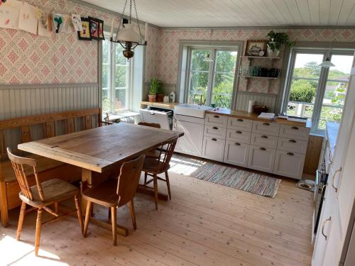 a kitchen with a wooden table and chairs in it at Beautiful house near the sea in Öckerö