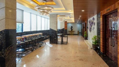 a hallway with tables and chairs in a building at Hotel Park Elanza Chennai in Chennai