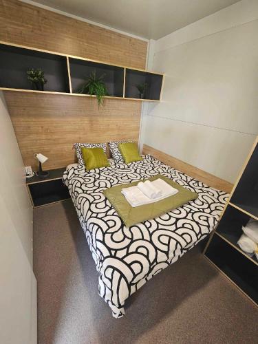 a bedroom with a large bed with a white and black at Mobile home Tortuga in Drage