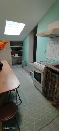 une cuisine avec une cuisinière et une table à l'intérieur dans l'établissement La Marynath, à Cholet