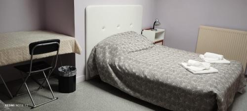 une petite chambre avec un lit et une chaise dans l'établissement La Marynath, à Cholet