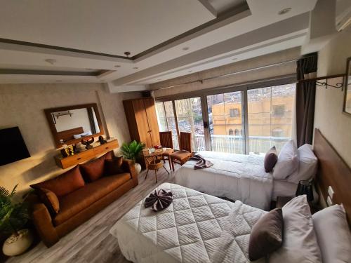 a room with two beds a couch and a mirror at tourist hotel cairo downtown in Cairo