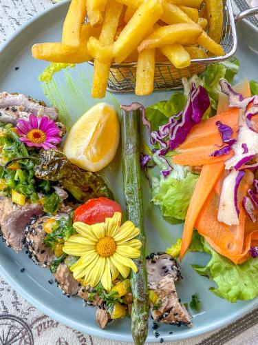 a plate of food with a salad and french fries at Relais de l’Hermitage Saint-Gilles in Saint-Gilles les Bains