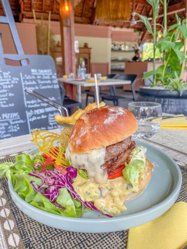 a sandwich on a plate with a salad on a table at Relais de l’Hermitage Saint-Gilles in Saint-Gilles les Bains