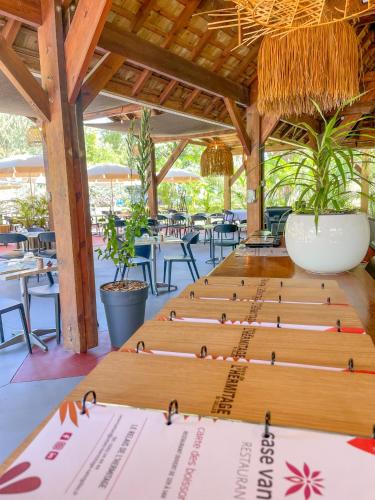 a row of wooden tables in a restaurant at Relais de l’Hermitage Saint-Gilles in Saint-Gilles les Bains