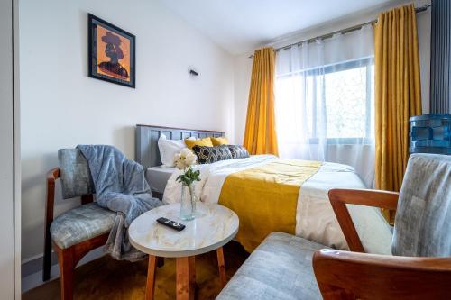 Un dormitorio con una cama y una mesa y sillas. en Modern Posh Studio at Luxore Apartments, en Nairobi