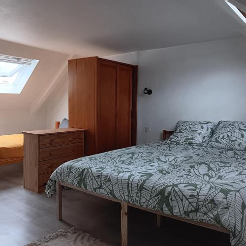 une chambre avec un lit et une commode en bois dans l'établissement Petite maison tranquille, à Pleugriffet