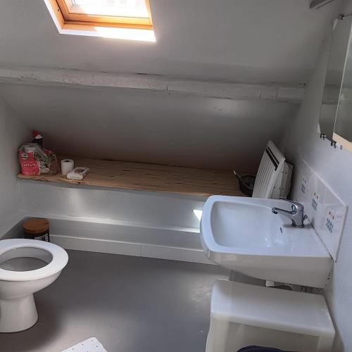 une salle de bain avec toilettes, lavabo et fenêtre dans l'établissement Petite maison tranquille, à Pleugriffet