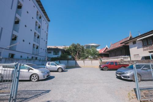 a parking lot with cars parked next to a building at Near Don Mueang Hotel in Don Muang Airport