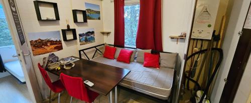 comedor con mesa y almohadas rojas en mobil-home 43, en La Roque-d'Anthéron