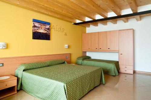 a bedroom with two beds and a yellow wall at Casa Citella in Bussolengo