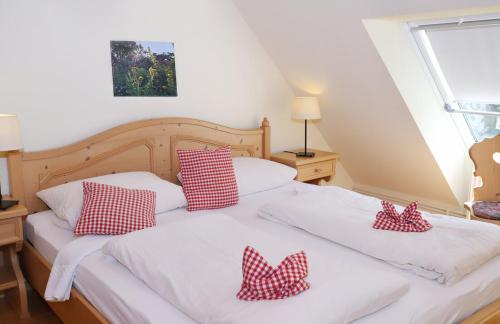 two beds with red and white pillows on them at Bauerncafé Sprengel in Bad Gandersheim