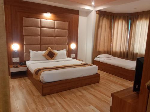 a hotel room with two beds and a television at Gold Nest Rubystone Heritage in Udaipur