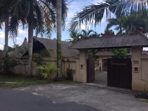 un bâtiment avec un portail et des palmiers dans l'établissement Villa Honai Bali, à Marga