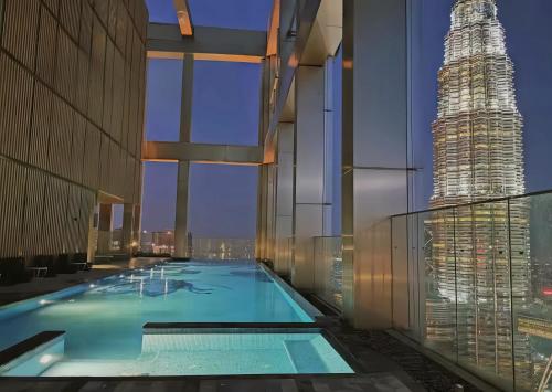 a swimming pool on the roof of a building with a skyscraper at Tropicana The Residence KLCC in Kuala Lumpur