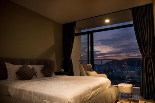 una camera da letto con un letto e una grande finestra di CSJ Seaside - Căn Hộ Cạnh Biển a Vung Tau
