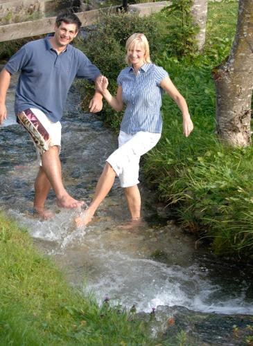 a man and a woman standing in a creek at Gästehaus Alte Bergmühle in Fischbachau