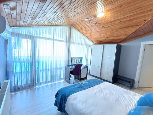 a bedroom with a bed and a desk and windows at Koçi Otel in Pazar