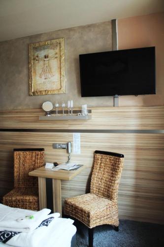 a hotel room with a tv and a table and chairs at Hotel Plzeň in Plzeň