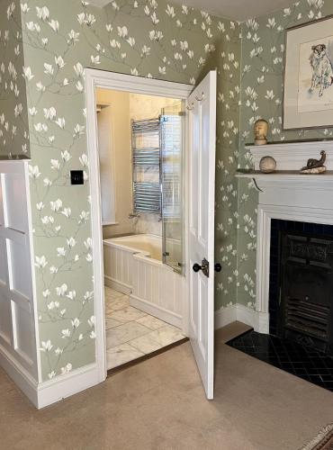 a bathroom with white flowers on the wall at Uplands Guest House in Ledbury