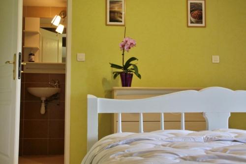 a bedroom with a white bed with a flower in a vase at Gite de felgines in Boisset