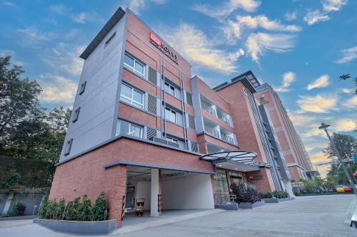 un edificio de ladrillo alto con un cartel. en GoSavvy Executive Residences - Three Bedroom, en Bangalore