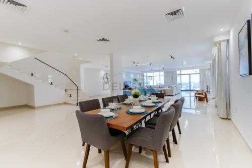 a dining room with a table and chairs at Overlooking Pool, Mountain and Sea 6BR Villa with Two Assistant Room, Heated Pool, BBQ Area, Al Dana Island, Fujairah by Deluxe Holiday Homes in Fujairah