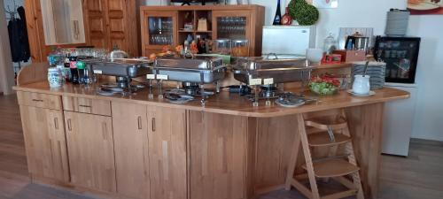 a kitchen counter with three sinks on a wooden island at Landhotel Solmser Hof GbR in Echzell