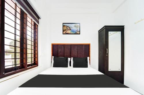 a bedroom with a bed and a window at Super Hotel O Attukal Near Attakulangara formerly Remya Residency in Trivandrum