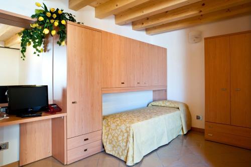 a bedroom with a bed and a cabinet with a television at Casa Citella in Bussolengo