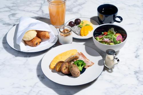 a table with plates of food and a bowl of salad at Canopy By Hilton Osaka Umeda in Osaka