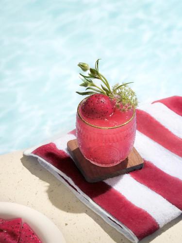 a red bowl with a plant in it sitting on a towel at Champton Hanoi Hotel in Hanoi