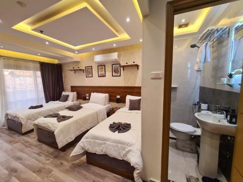 a hotel room with two beds and a sink at tourist hotel cairo downtown in Cairo