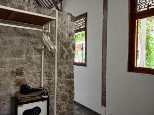 a room with a stone wall and two windows at Sun Moon Star Villas with One Bedroom Private in Jarakan