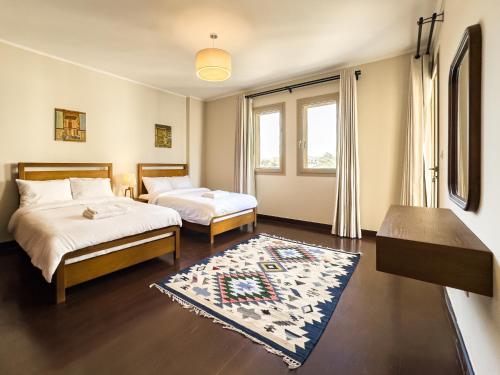 ein Schlafzimmer mit zwei Betten und einem Teppich in der Unterkunft Sunny Cairo City Center l Serviced l Golf l Pool l Gym l 2 in Kairo