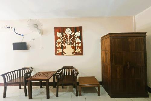 a dining room with two chairs and a table and a painting at Thai Gallery Baantawai in Chiang Mai