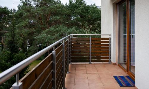 a balcony of a house with trees in the background at Wczasowa, Sun & Snow in Ustka