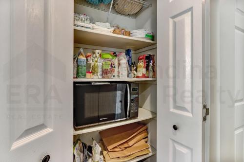 a kitchen pantry with a microwave on a shelf at 2505B W, 5th St condo in Fernandina Beach