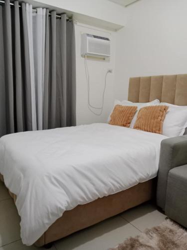 a bedroom with a bed and a couch at Studio 7 Residential Building in Manila