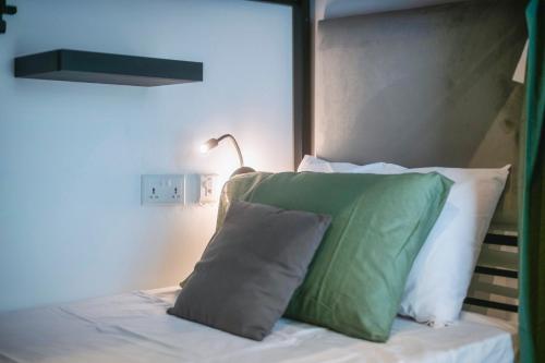 a bed with a green pillow and a lamp at Mandera's Boutique Suites & Dorms in Valletta