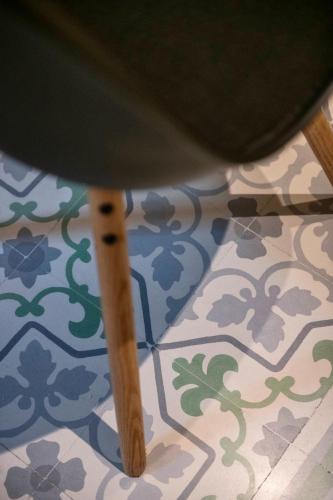 a stool sitting on a floor with a tile floor at Mandera's Boutique Suites & Dorms in Valletta