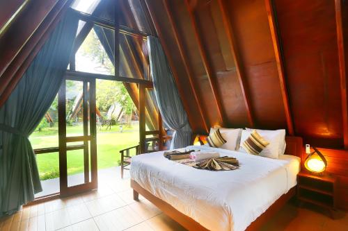 une chambre avec un lit et une grande fenêtre dans l'établissement Dewantara Boutique Villa Resort Bali, à Umeanyar