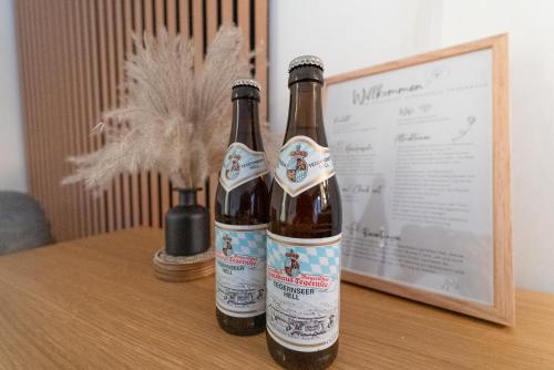 zwei Flaschen Bier auf dem Tisch in der Unterkunft Zentrales Apartment mit Balkon direkt am Wanderweg - Alpenperle Tegernsee in Tegernsee