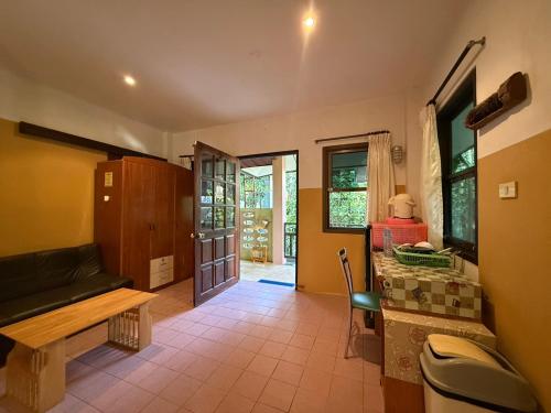 a living room with a couch and a table and a desk at Sawasdee House in Lamai