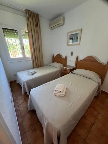 a hotel room with two beds with towels on them at Marbella Villas in Marbella