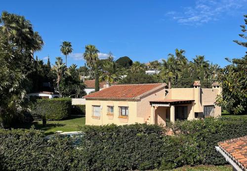 a house in a yard with trees and bushes at Marbella Villas in Marbella
