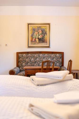 a room with two beds and a table and a couch at Gästehaus Goldener Stern in Lienz