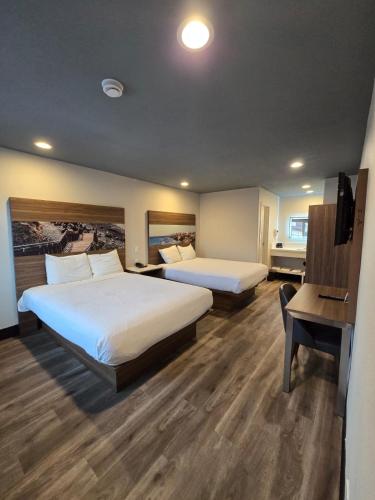 a hotel room with two beds and a desk at Hyland Inn near Legoland in Carlsbad