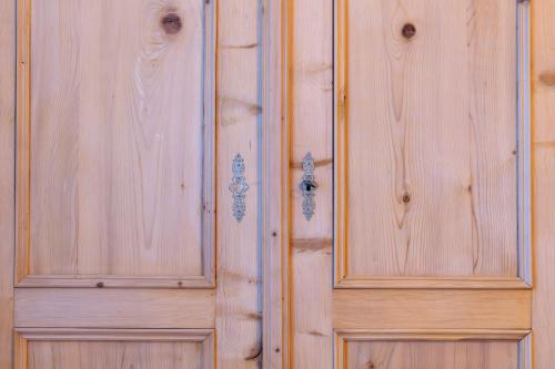 a wooden cabinet with two doors on a wall at Gästehaus Goldener Stern in Lienz